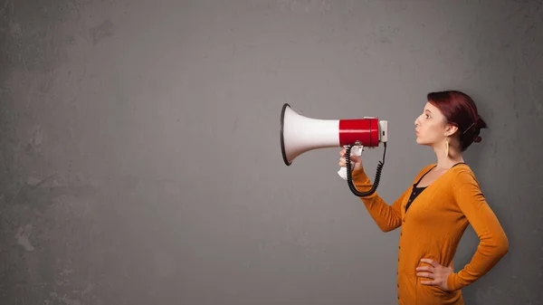 Meisje schreeuwen in megafoon op kopieerruimte achtergrond — Stockfoto