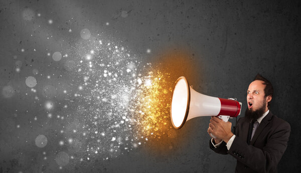 Парень, кричащий в мегафон и пылающие частицы энергии взрываются