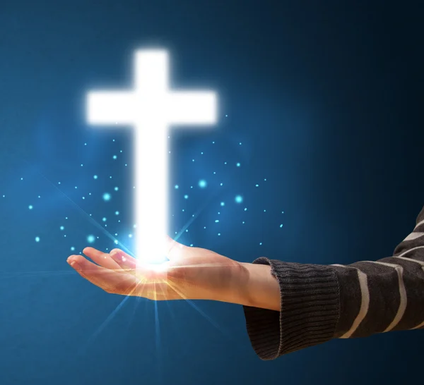 Glowing cross in the hand of a woman — Stock Photo, Image