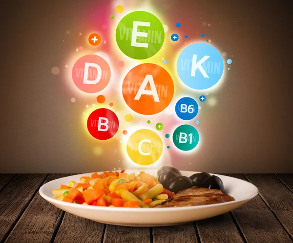 Placa de comida con deliciosa comida y saludables símbolos vitamínicos — Foto de Stock