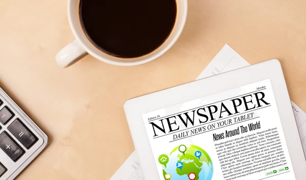 Tablet pc shows news on screen with a cup of coffee on a desk — Stock Photo, Image