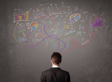 Genç iş adamı çizimlere ve sembollere bakıyor.