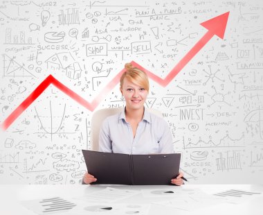 Piyasa diyagramlarıyla masada oturan iş kadını.
