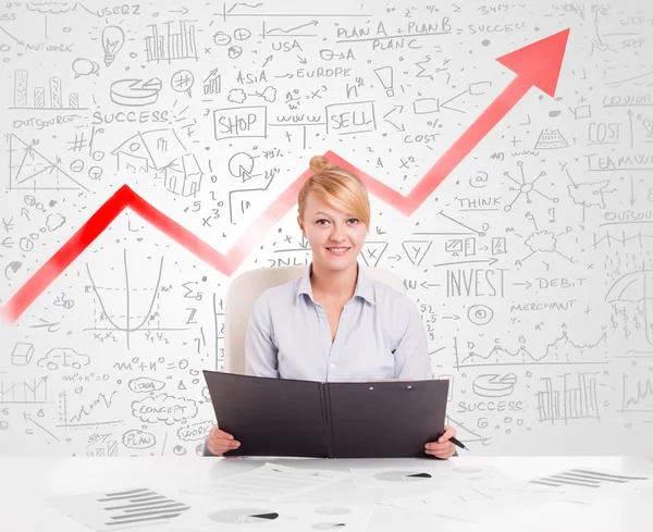 Piyasa diyagramlarıyla masada oturan iş kadını.