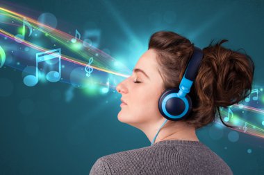 Kulaklıkla müzik dinleyen genç bir kadın.