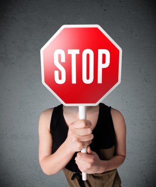 Elinde dur tabelası tutan genç bir kadın.