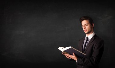 Genç adam kitap okuyor.