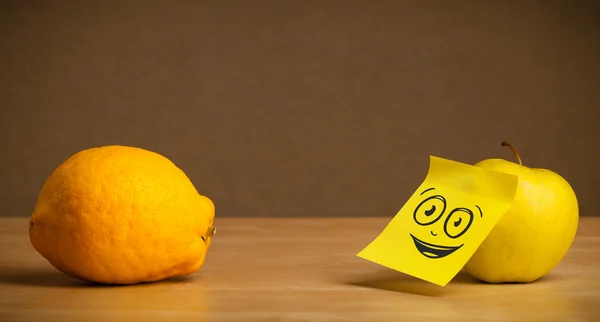 Apple with post-it note watching at lemon — Stock Photo, Image