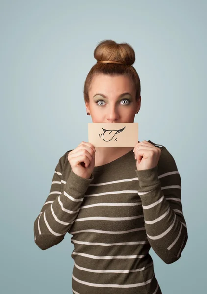 Pretty young girl holding white card with smile drawing — Stock Photo, Image