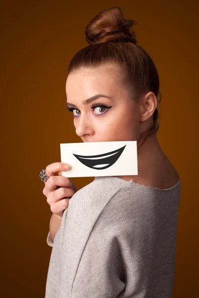 Ευτυχής όμορφη γυναίκα, κρατώντας την κάρτα με αστεία smiley — Φωτογραφία Αρχείου