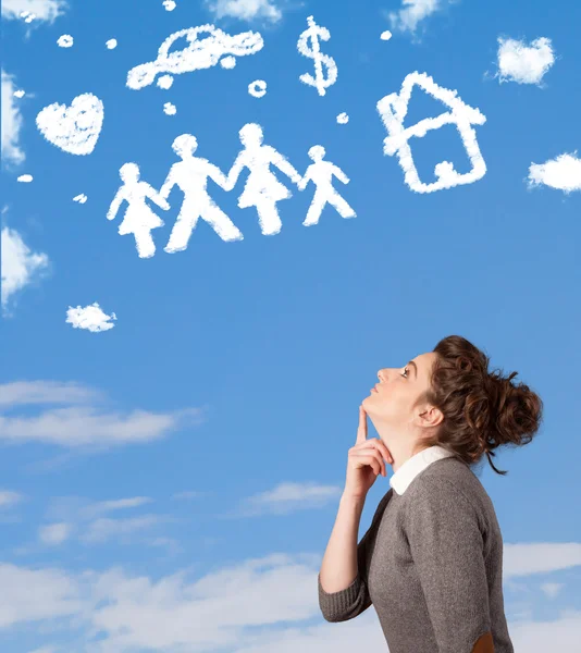 Chica joven soñando despierto con la familia y las nubes del hogar —  Fotos de Stock