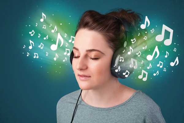 Kulaklıklı genç bir kadın müzik dinliyor.