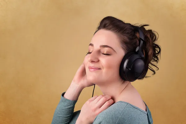 Young woman with headphones listening to music with copy space — Stock Photo, Image