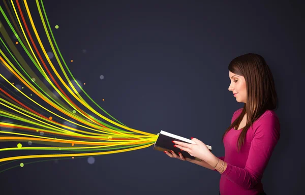 Mulher muito jovem lendo um livro enquanto linhas coloridas estão chegando — Fotografia de Stock