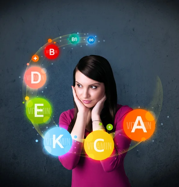 Young woman thinking with vitamins circulation around her head — Stock Photo, Image