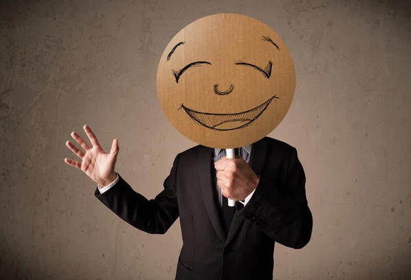 Businessman holding a smiley face board — Stock Photo, Image