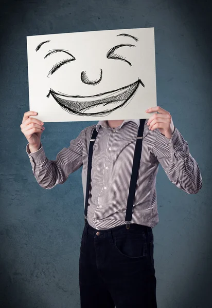 Uomo d'affari in possesso di un foglio con la faccia sorridente di fronte alla sua hea — Foto Stock