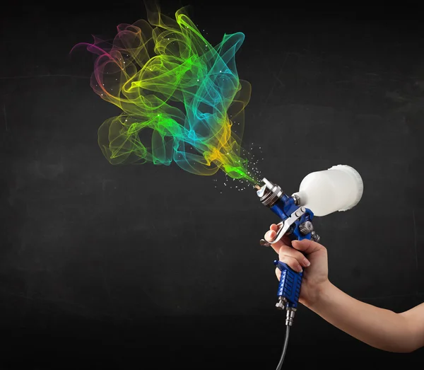 Maler arbeitet mit Airbrush und malt bunte Farbe — Stockfoto