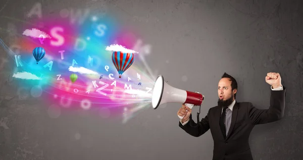 Man shouting into megaphone and abstract text and balloons come — Stock Photo, Image