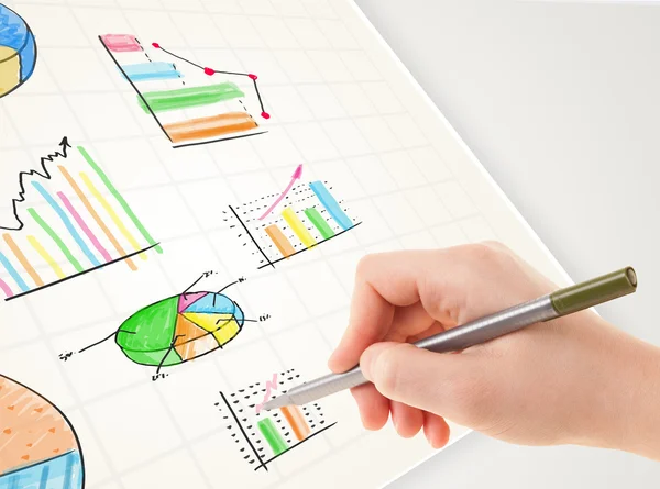 Affärsperson rita färgglada grafer och ikoner på papper — Stockfoto