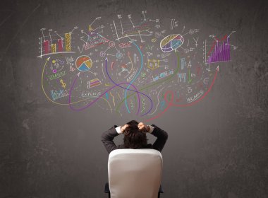 Genç iş adamı çizimlere ve sembollere bakıyor.