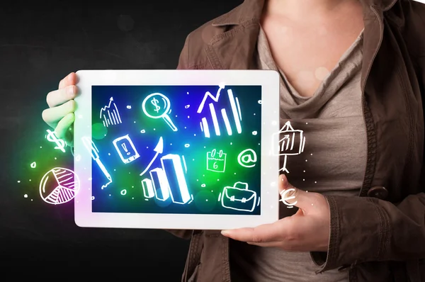 Young person holding tablet with graph and chart symbols — Stock Photo, Image