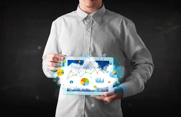 Людина, що тримає тачпад з хмарними технологіями та графіками — стокове фото