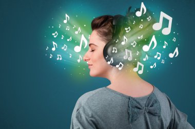 Kulaklıklı genç bir kadın müzik dinliyor.