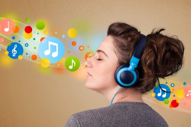 Kulaklıkla müzik dinleyen genç bir kadın.