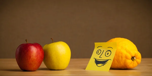 Lemon with post-it note smiling at apple — Stock Photo, Image