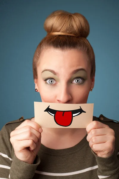 Happy pretty woman holding card with funny smiley — Stock Photo, Image