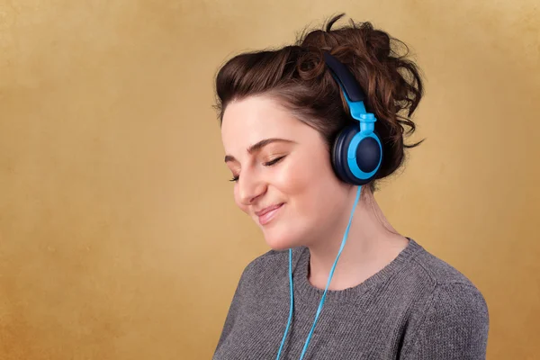 Jeune femme avec écouteurs écoutant de la musique avec espace de copie — Photo