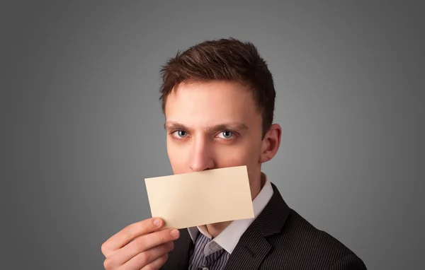 Businessman holding white card at front of her lips with copy sp — Stock Photo, Image