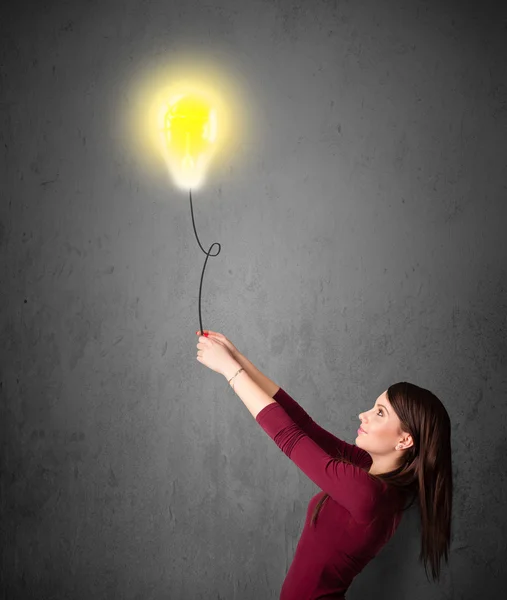 Frau hält einen Ballon mit Glühbirnen — Stockfoto