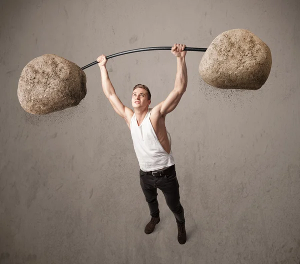 Hombre muscular levantando grandes pesos de piedra de roca —  Fotos de Stock