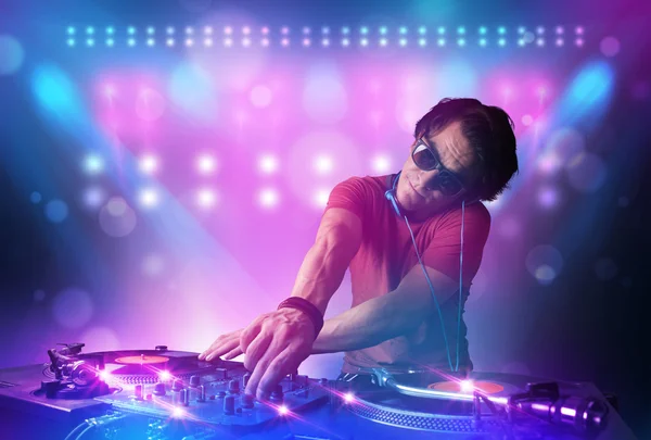 Disc jockey mixando musica sui giradischi sul palco con luci e — Foto Stock