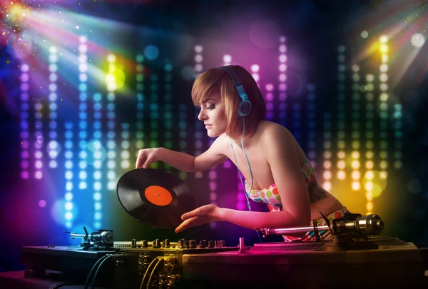 Девочка-диджей играет песни на дискотеке со световым шоу — стоковое фото