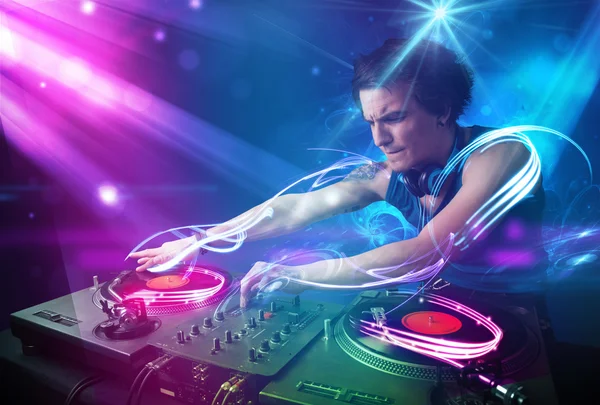 Energiska dj blandande musik med kraftfulla ljuseffekter — Stockfoto