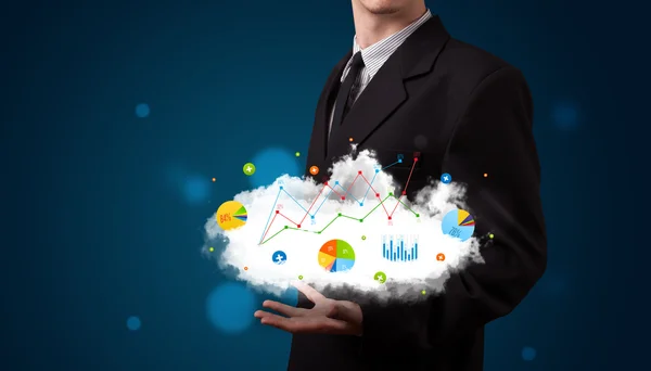 Young businessman presenting cloud with charts and graph icons a — Stock Photo, Image