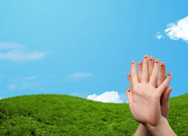 Веселые улыбки на пальцах на фоне пейзажа — стоковое фото