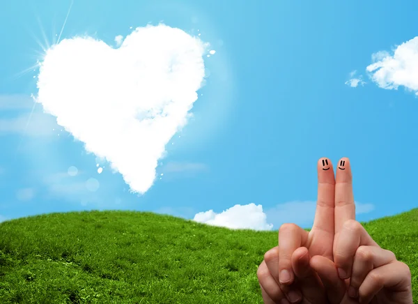 Счастливые улыбающиеся пальцы смотрят на облако в форме сердца — стоковое фото