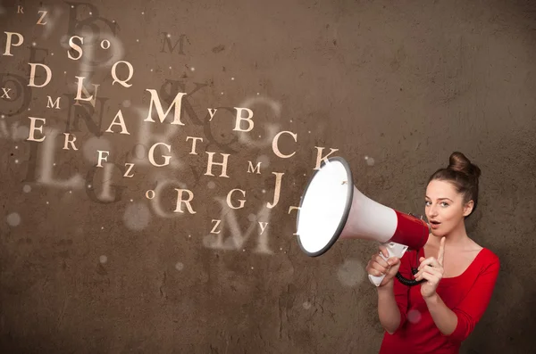 Ung flicka skriker in i megafon och text kommer ut — Stockfoto