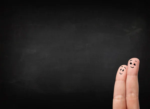 Happy smiley fingers looking at empty black chalboard — Stock Photo, Image