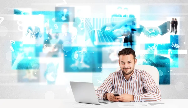 Business person at desk with modern tech images at background — Stock Photo, Image