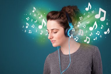 Kulaklıklı genç bir kadın müzik dinliyor.