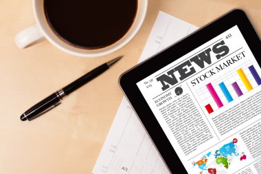 Tablet bilgisayarı haberleri ekranda bir fincan kahveyle sunar.