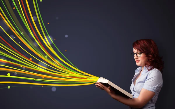 Ganska ung kvinna läser en bok medan färgglada linjer comin — Stockfoto