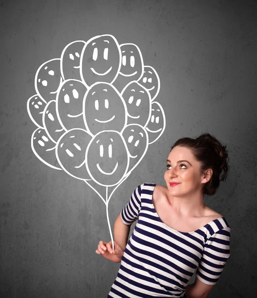 Frau hält ein Bündel lächelnder Luftballons in der Hand — Stockfoto