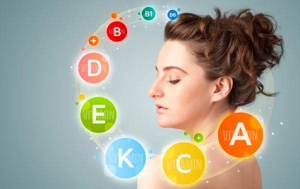 Pretty young girl with colorful vitamin icons and symbols — Stock Photo, Image