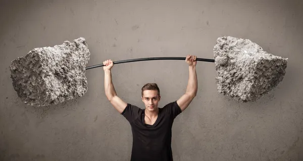 Muscular man lifting large rock stone weights — Stock Photo, Image